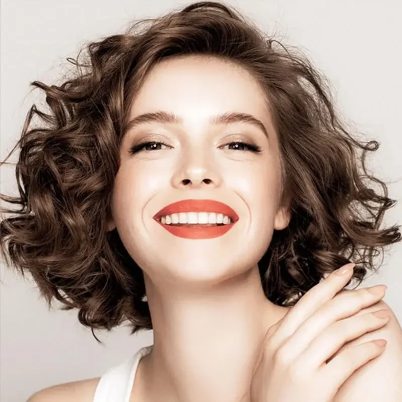Smiling woman in a white top, an editorial portrait from Modern Touch Dental's previous website.