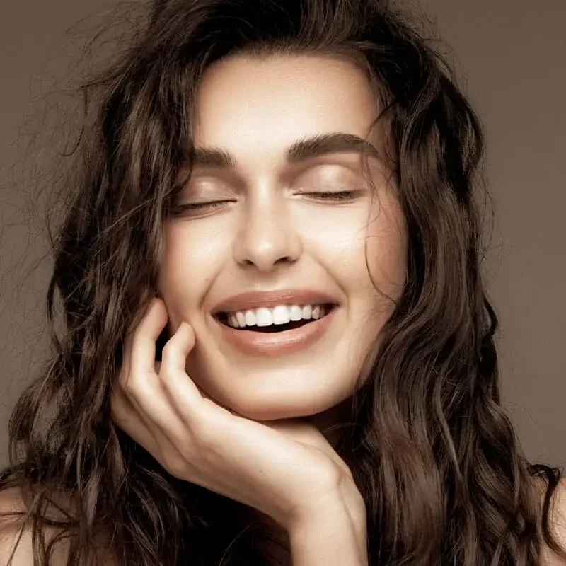 Smiling woman with dark hair, an editorial portrait from Modern Touch Dental's previous website.